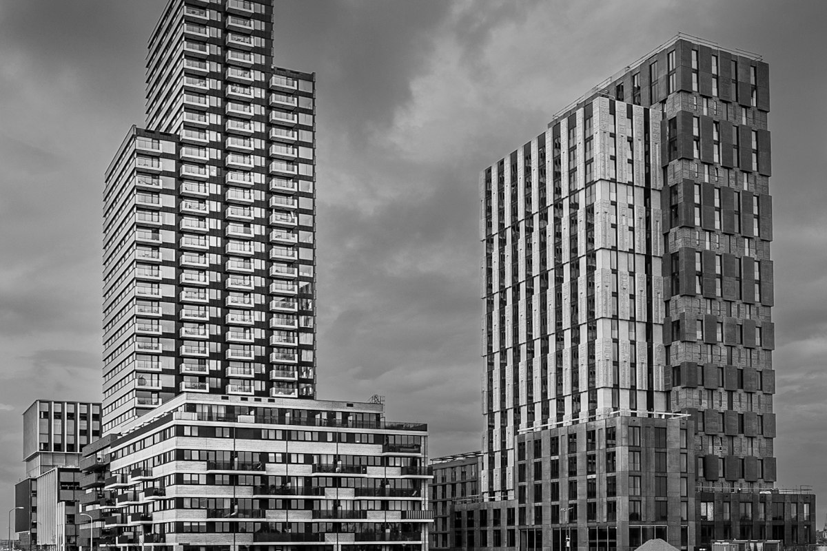 Twee nieuwe woontorens in zwart-wit tegen een bewolkte lucht