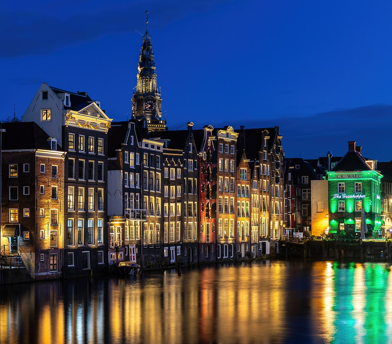 Grachtenpanden met de Oude Kerk op de achtergrond in Amsterdam