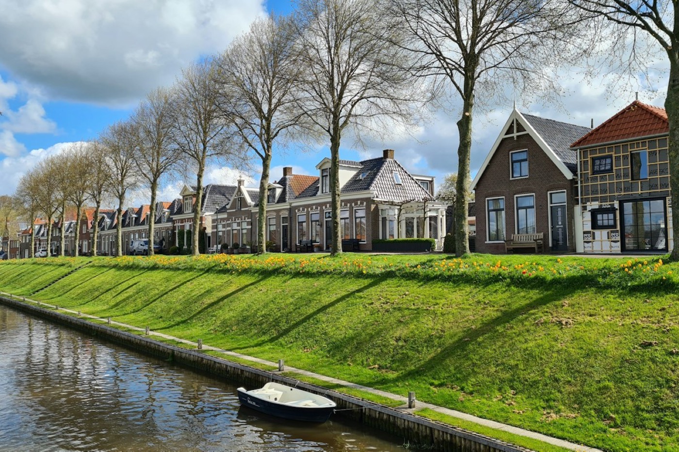 Woonhuis aan een rivier in een Nederlands dorp