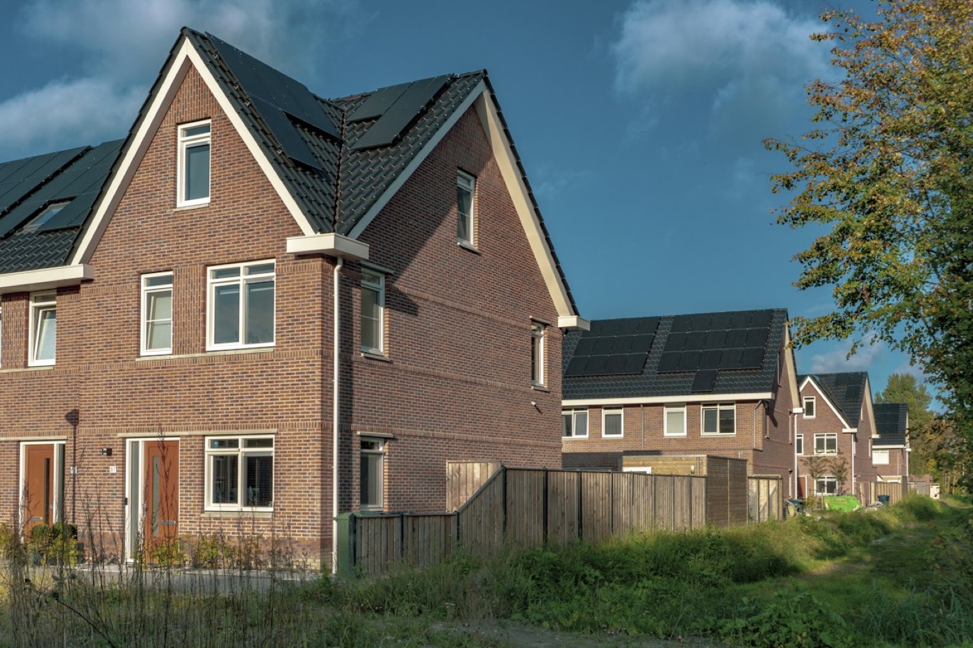 Rij nieuwe bakstenen eengezinswoningen met zonnepanelen