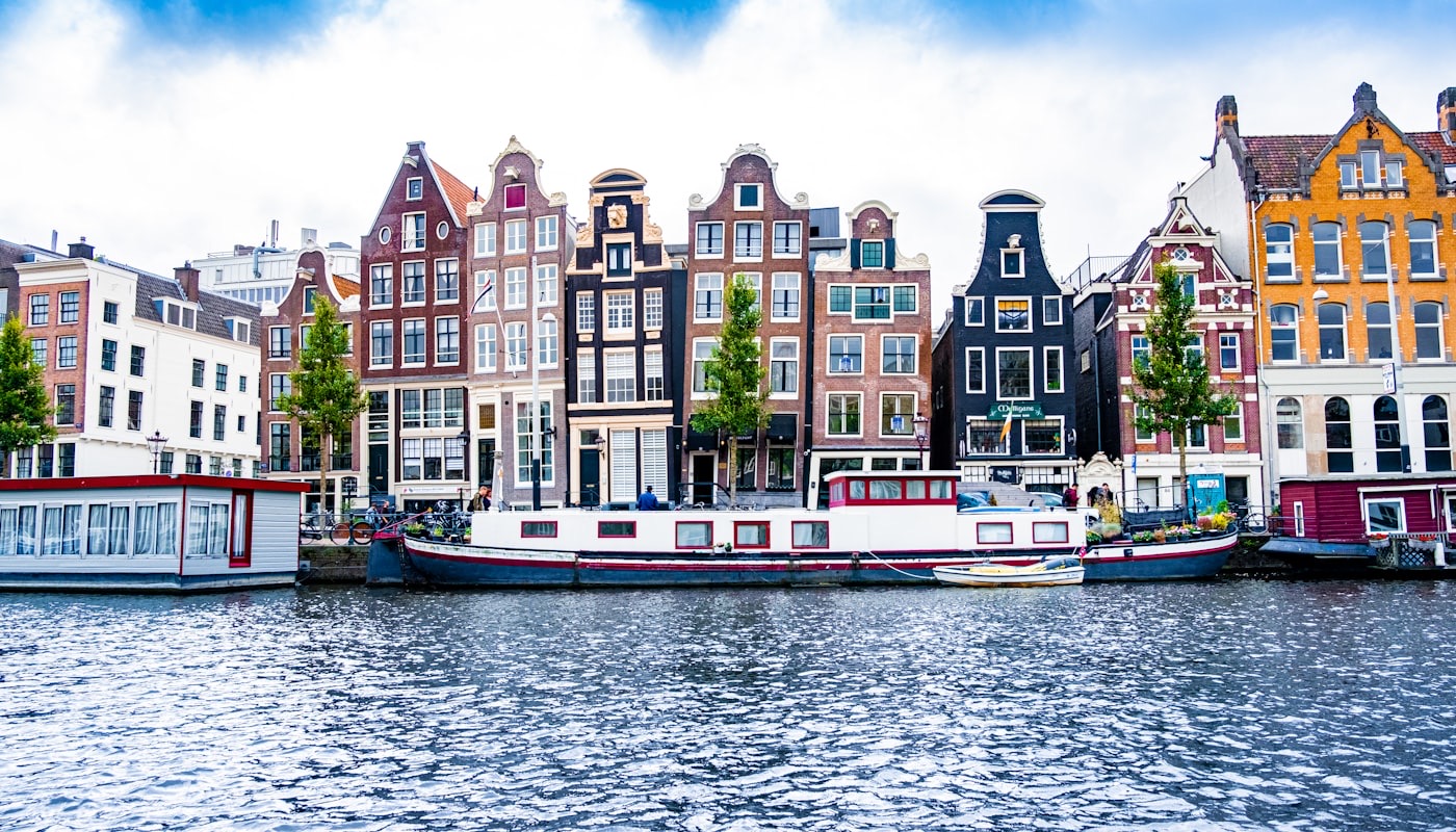 Nederlandse grachtenpanden aan het water onder een blauwe lucht
