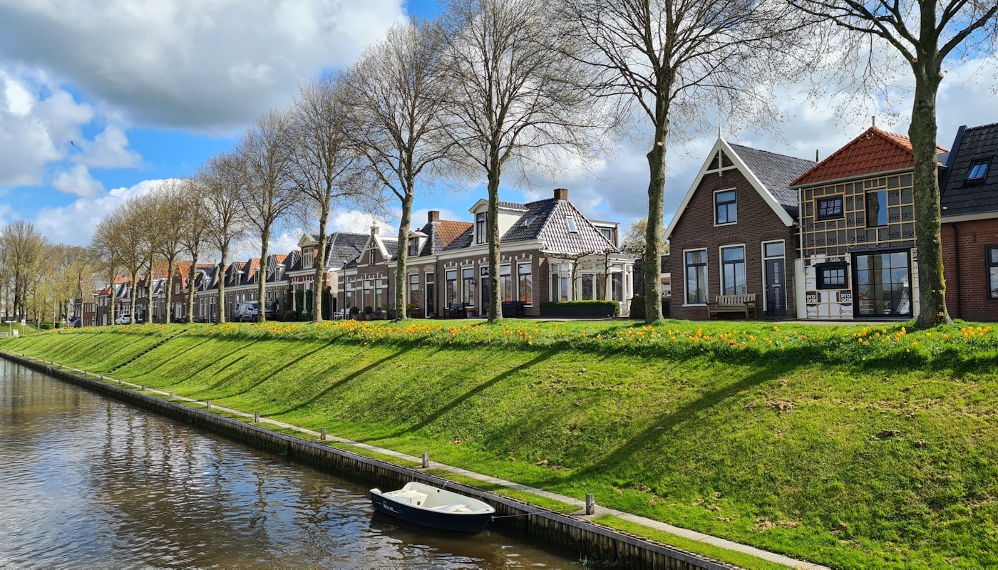 Woonhuis aan een rivier in Nederland op een zonnige dag